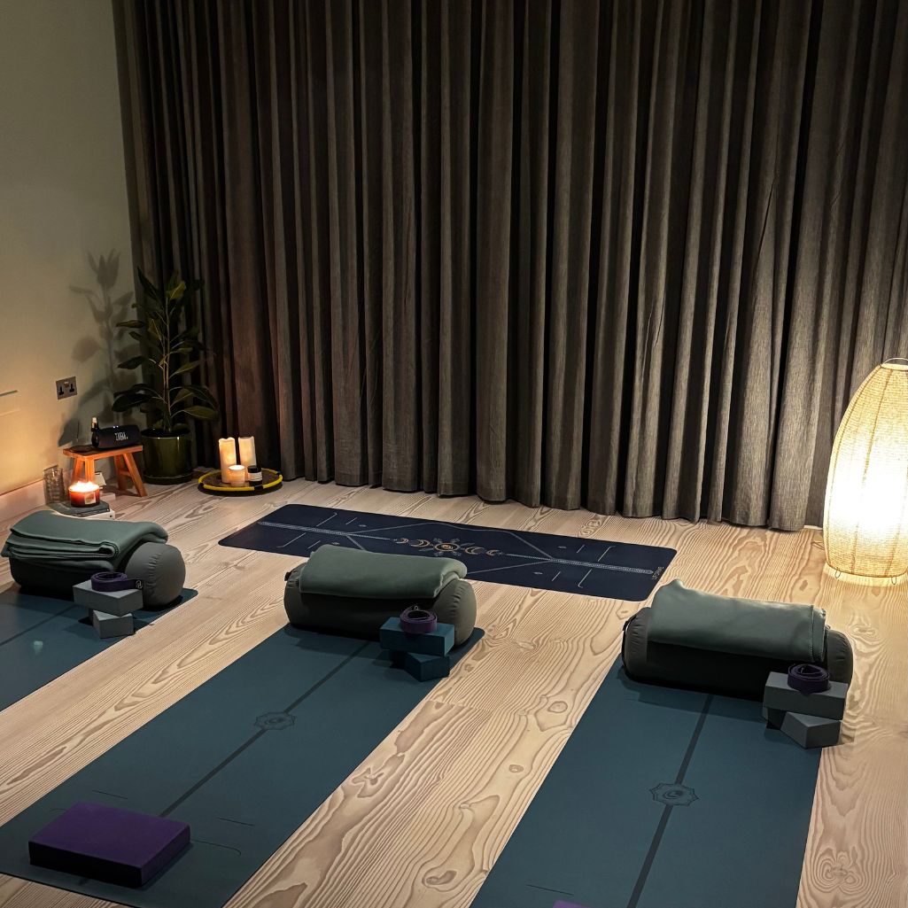 an evening yoga studio setting with mats, blankets, bricks and straps ready for class